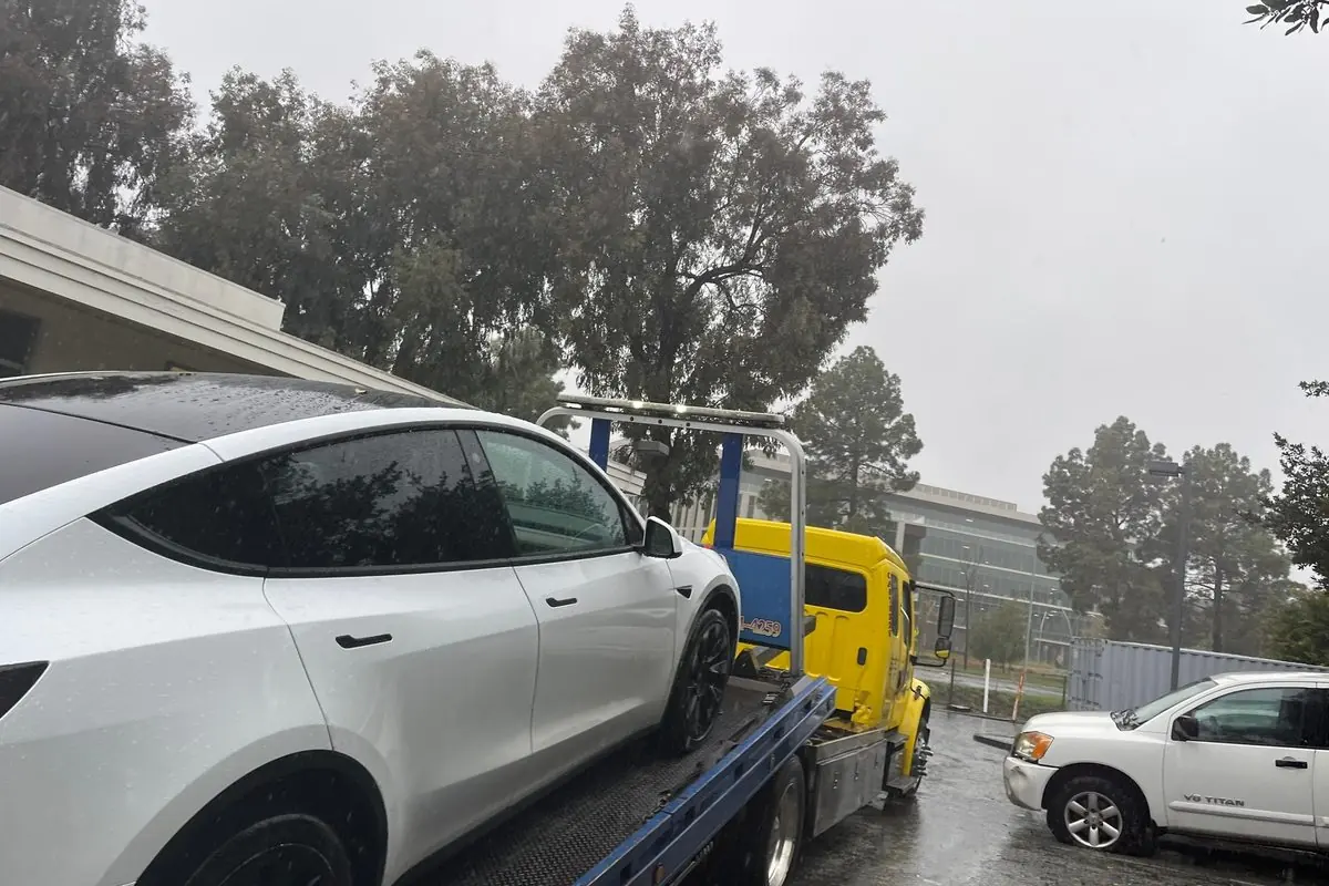 Tesla Model Y secured on a Guerra Towing flat bed in the rain in San Jose