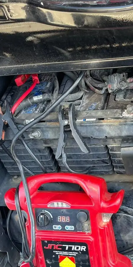 Cables de arranque conectados a un banco de baterías de un camión durante una llamada de asistencia para arranque de Guerra Towing
