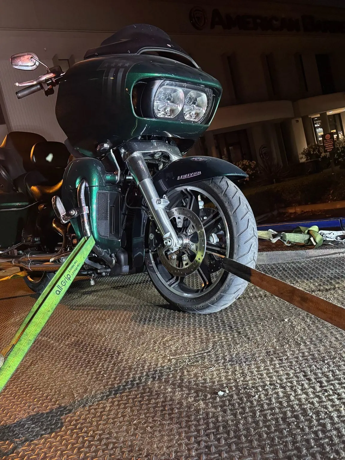 Una Harley-Davidson Road Glide sujeta en posición vertical en la plataforma de Guerra Towing durante la noche