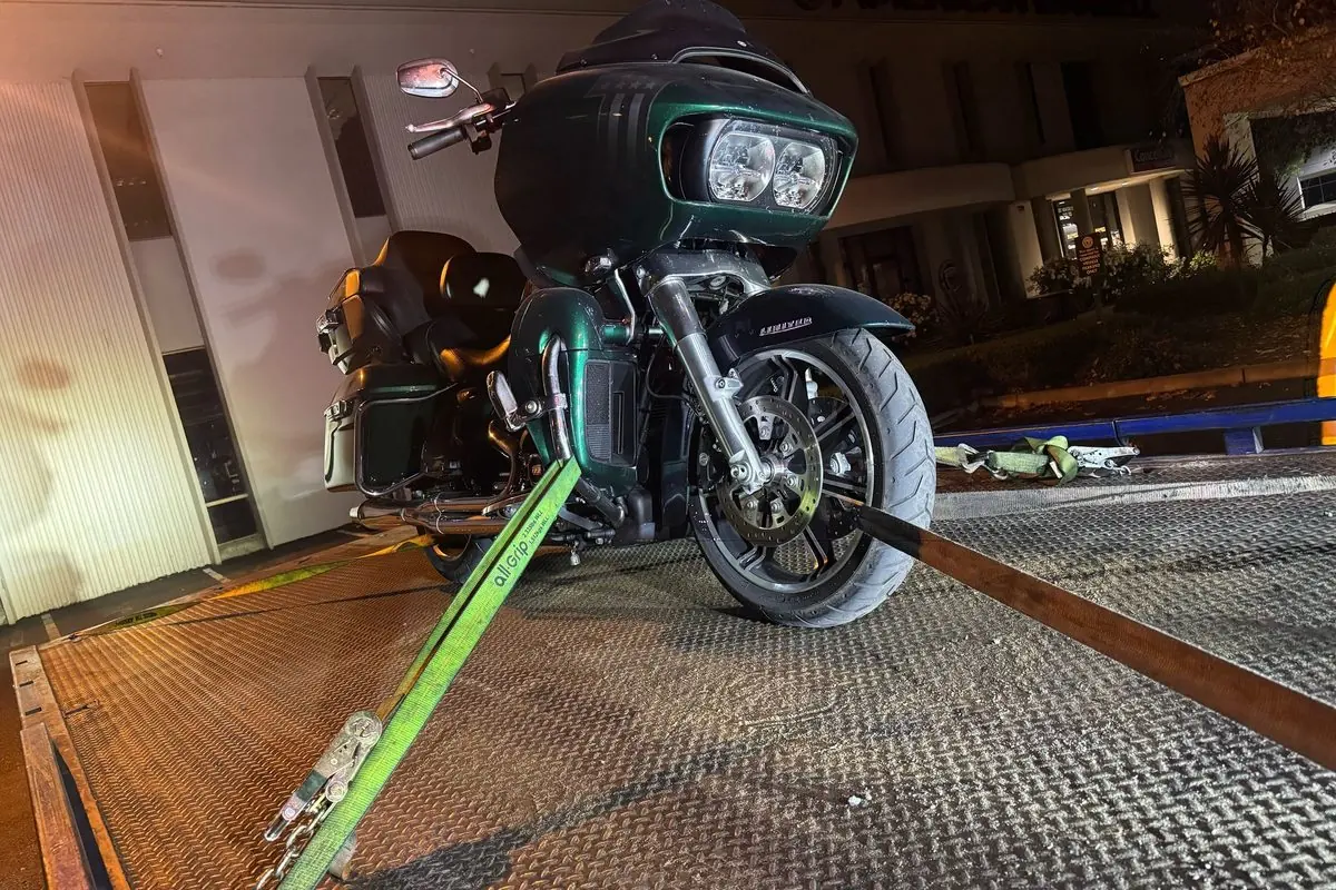 Harley-Davidson Road Glide strapped upright on a Guerra Towing deck at night