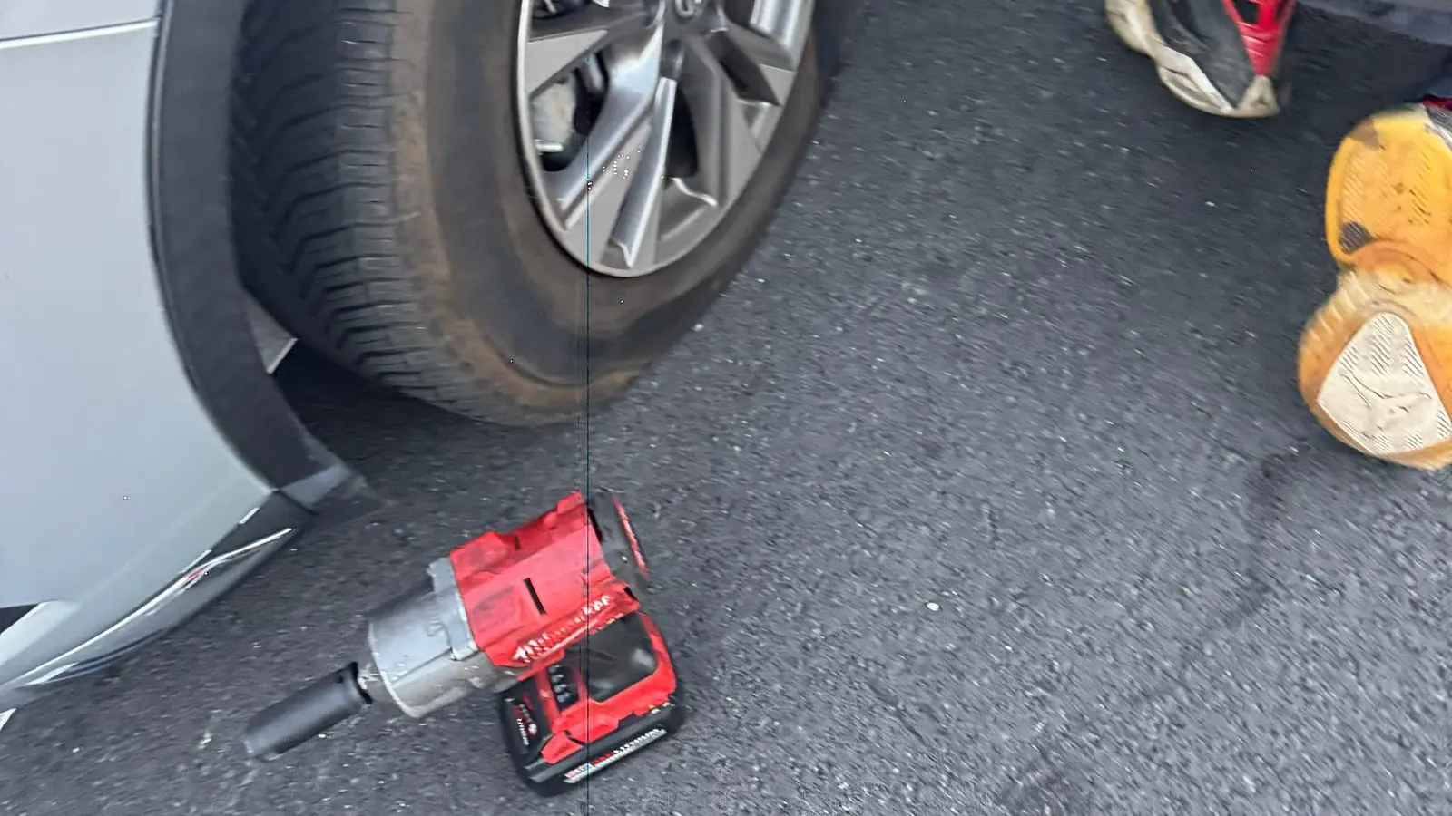 Llave de impacto y gato en el suelo junto a una rueda durante un cambio de llanta de Guerra Towing en San José