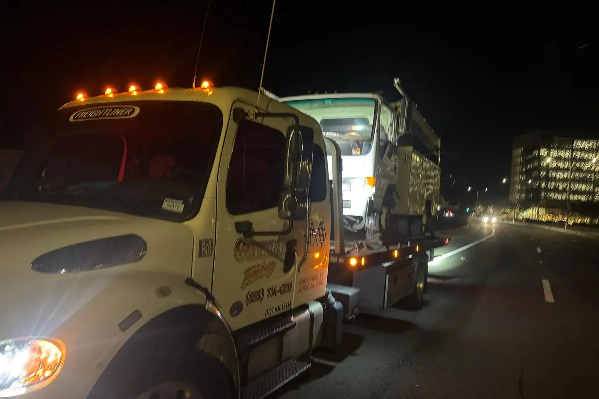 Guerra Towing truck running its marker lights on a San Jose road at night