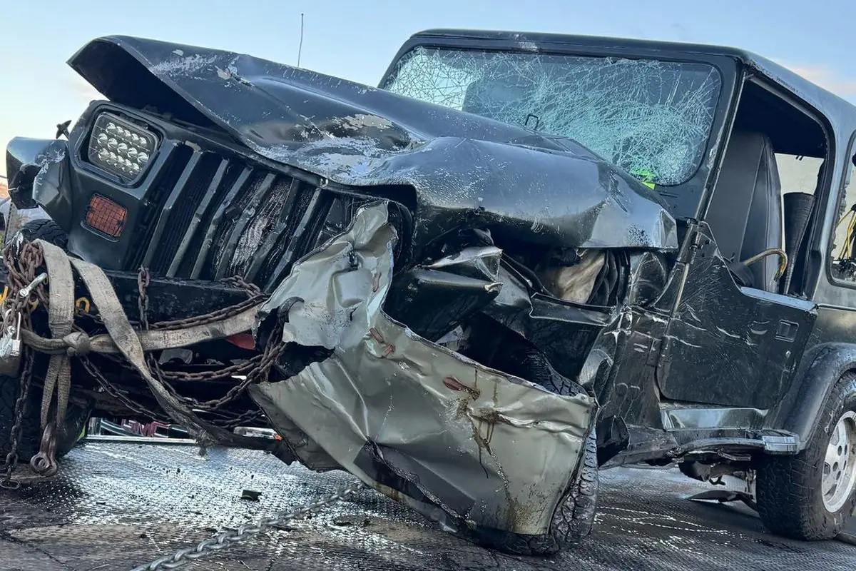 Wrecked Jeep Wrangler chained down on a Guerra Towing truck after a recovery in San Jose
