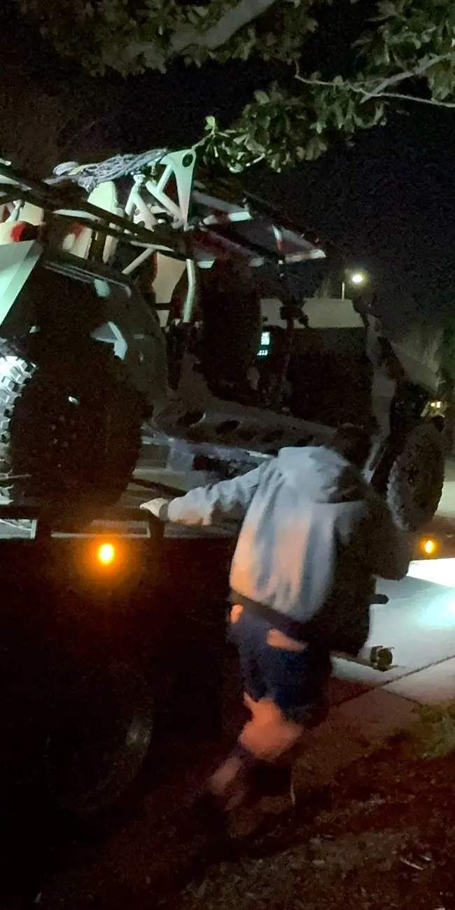 Guerra Towing crew member securing an off-road buggy on the deck at night